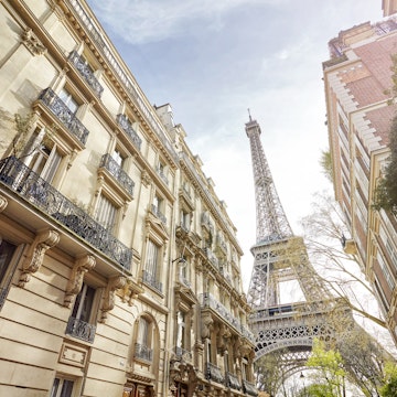 Low-angle view of the Eiffel Tower, as seen from a Paris street.